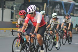 A group of people riding bikes down a street